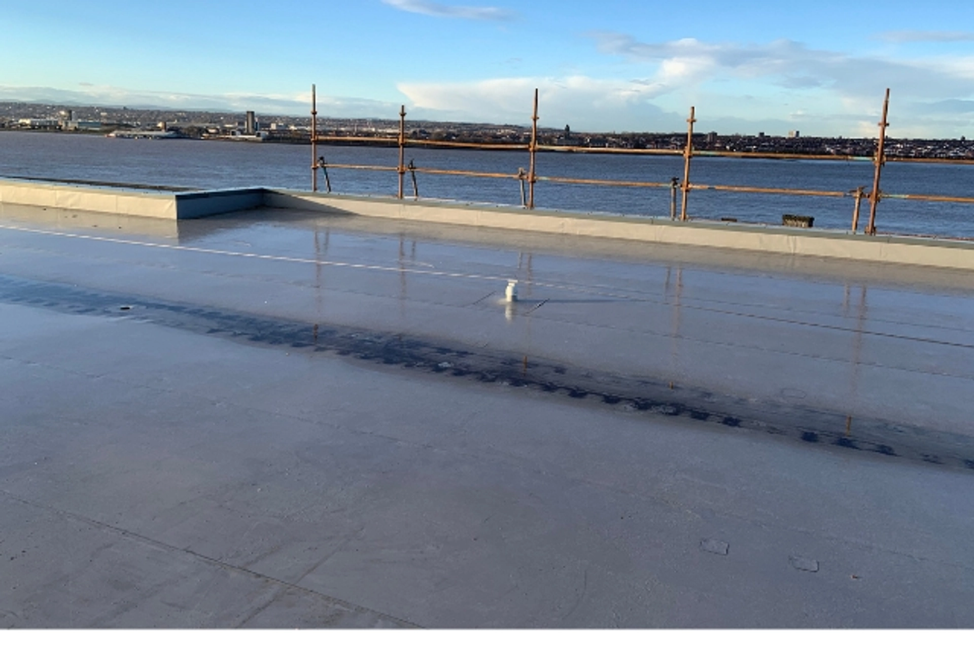Crew installing a durable flat roofing system on an industrial unit